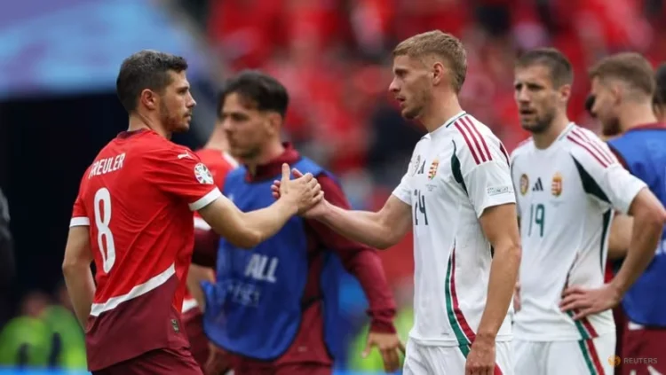 Pemain Hongaria, Marton Dardai berjabat tangan dengan pemain Swiss, Remo Freuler